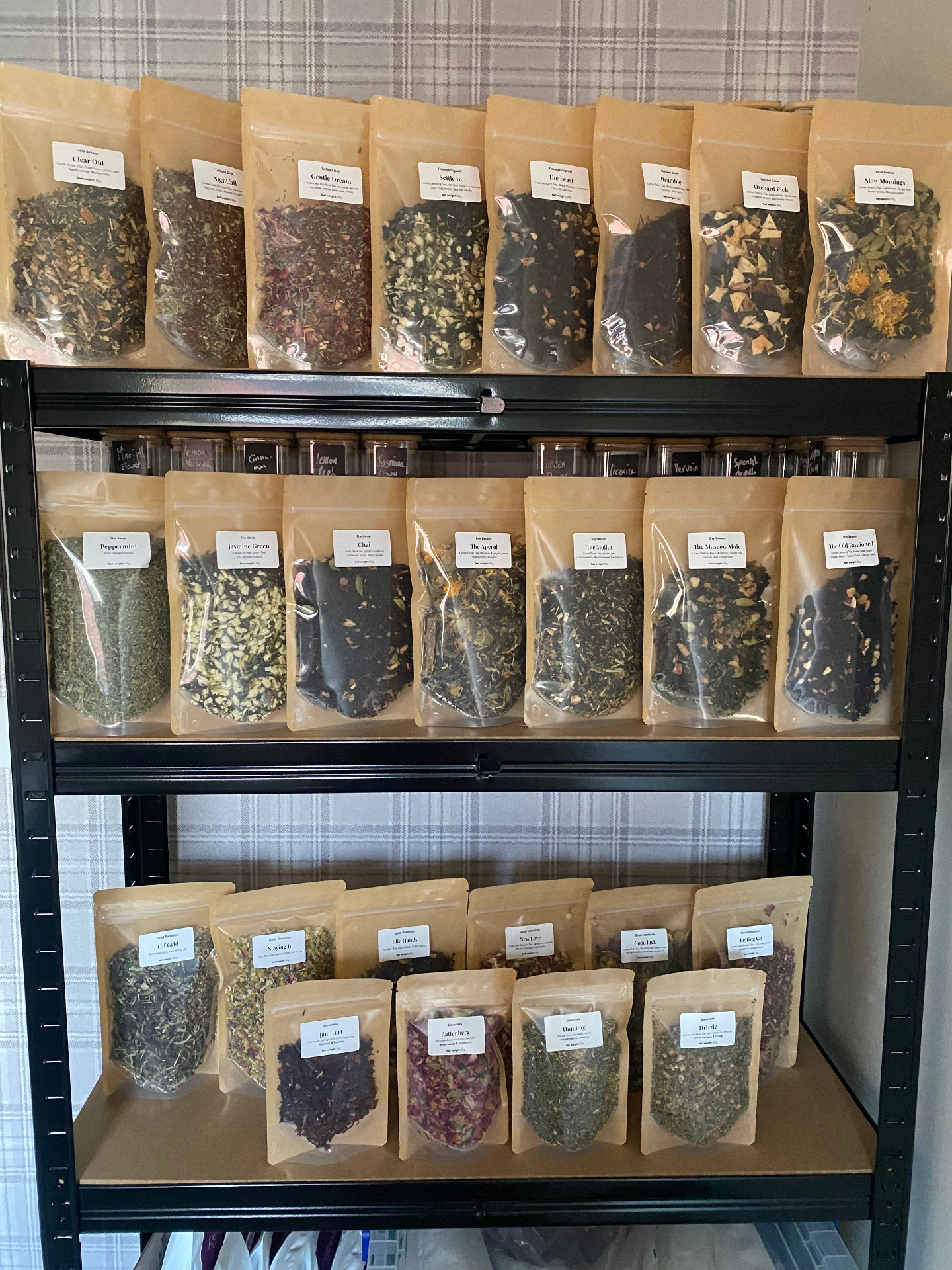 Shelves of hand blended Wild Steep loose leaf tea pouches, each labelled by hand.